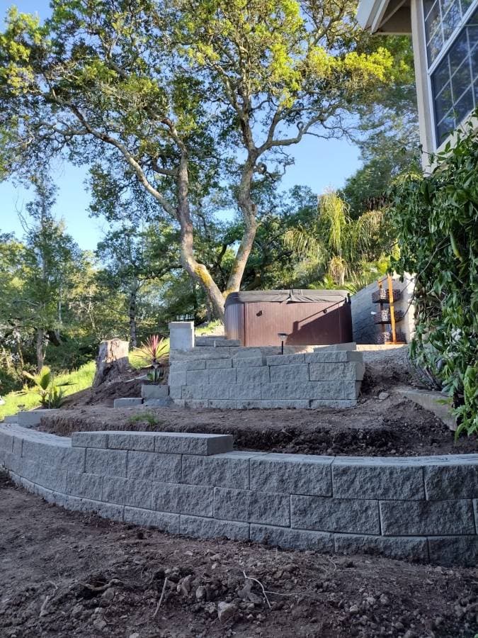 Backyard construction project with concrete foundation and grading work