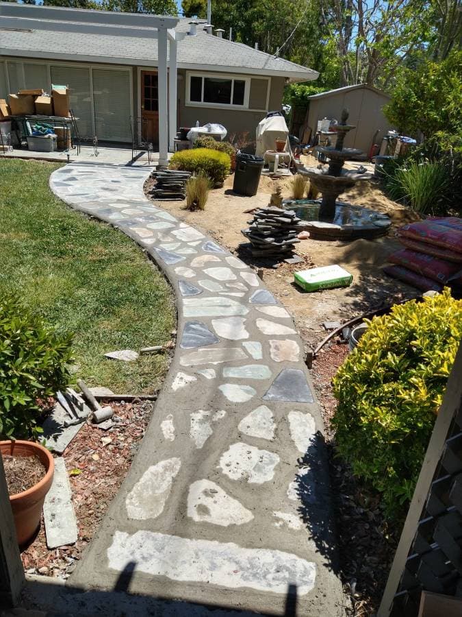 Stone walkway installation with curved path and clean landscape edging